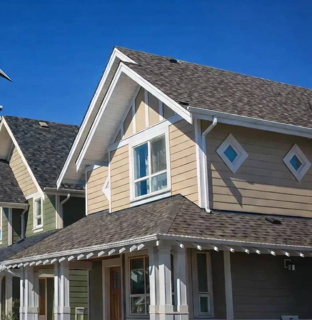 Row of homes with new asphalt shingle roofs under a clear sky
